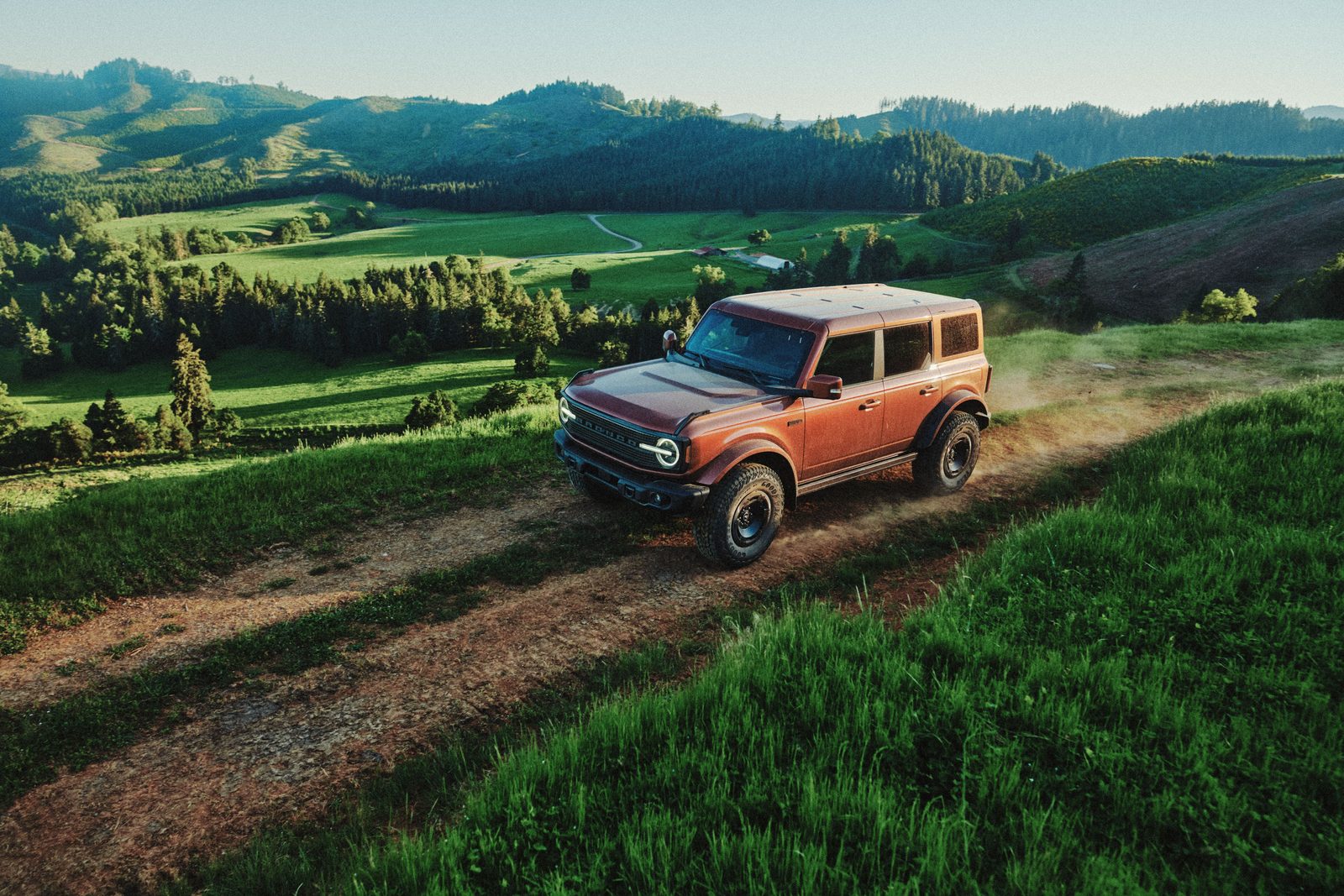 2027 Ford Bronco Filson First Edition in Iron Sands Copper on a dirt trail above a valley